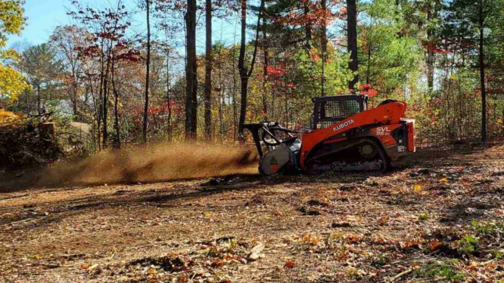 Skid steer clearing brush and grinding it down.